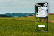 Panorama Feldansicht mit Bild eines Handys, auf dem die FALBY App installiert ist.