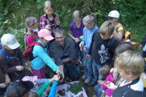 Schulkinder umringen den Förster. 