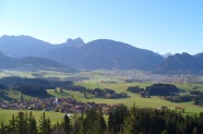 Bergige Landschaft, teils bewaldet, teils Grünland